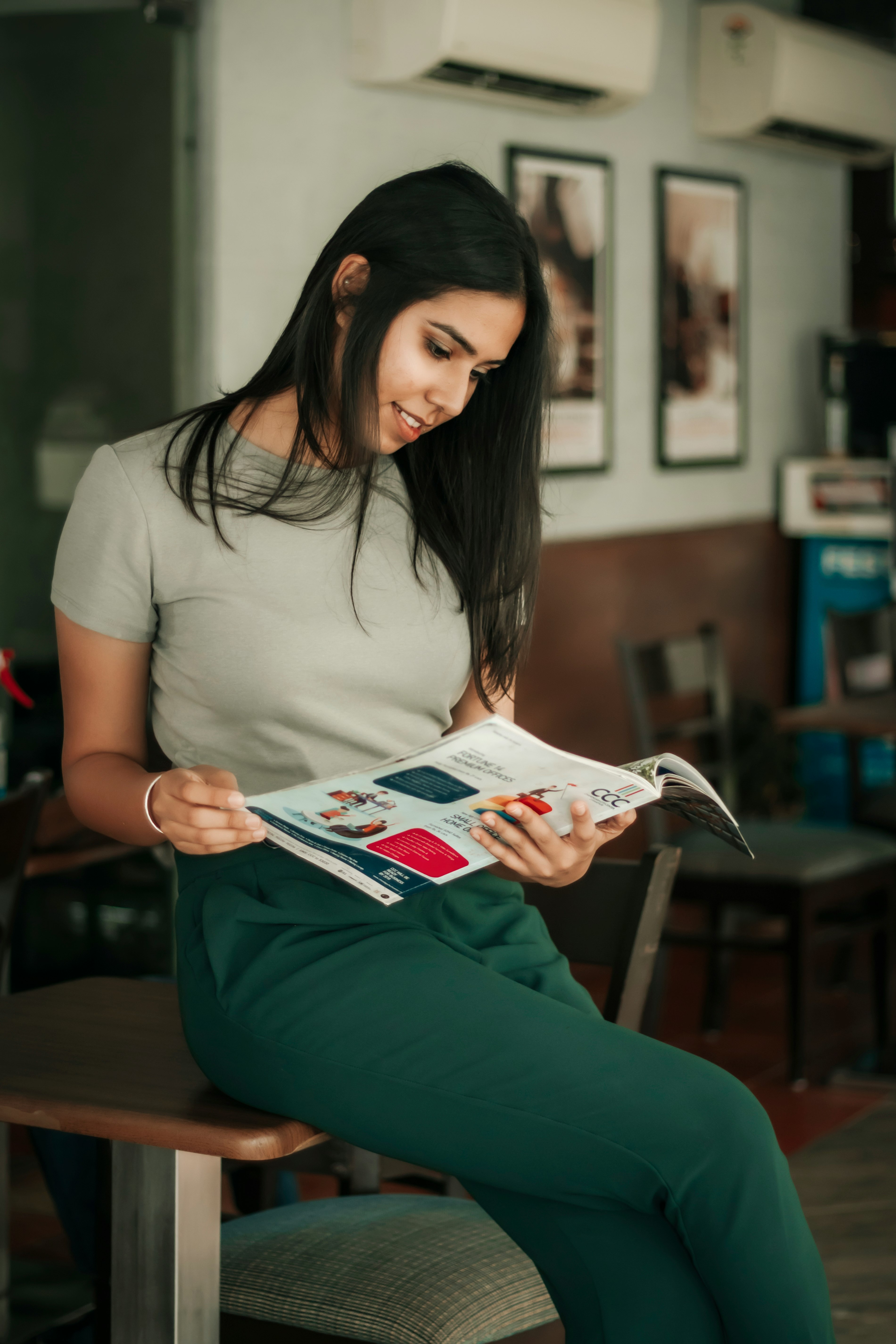 woman in white t-shirt reading magazine